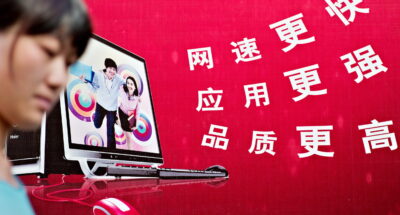 A woman walks past a billboard advertisi A woman walks past a chinese billboard advertising