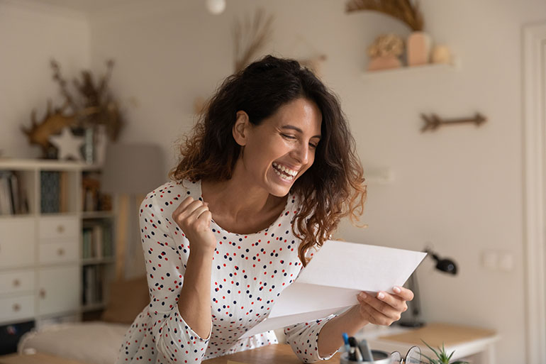 Overjoyed woman reading letter, celebrating success, received unexpected good news - IMD Business School women in leadership - IMD Business School