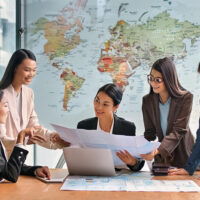 Diverse businesswomen discussing a project with map in front of them